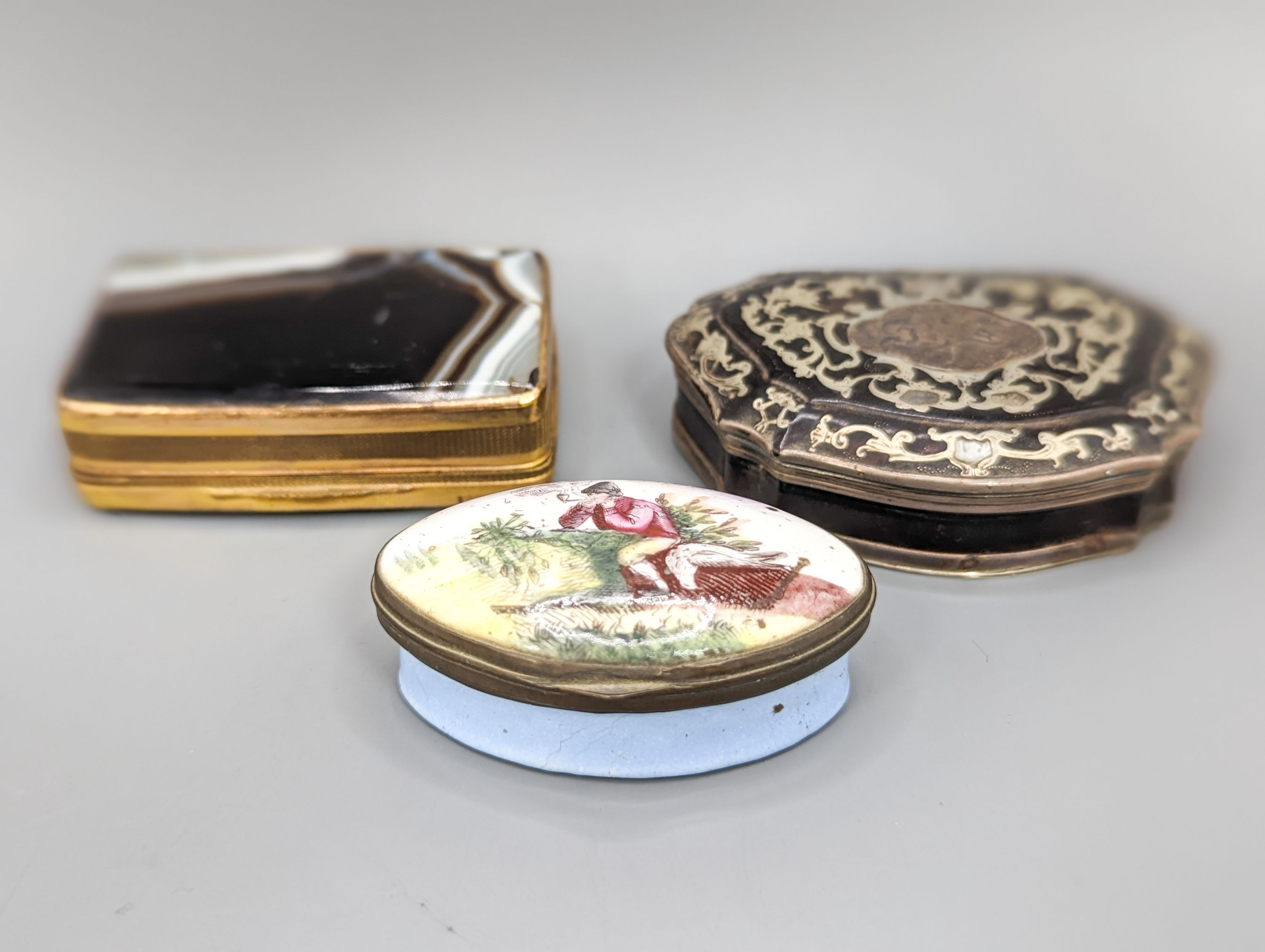 An 18th century silver inlaid tortoiseshell cartouche shaped snuff box, 7.4cm, an agate snuff box and Staffordshire enamel box (3)